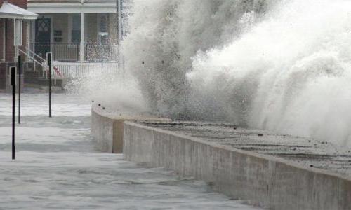 wave breaking on sea wall flooding neighborhood